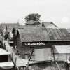 Fishing shanties on the north side of the Leland River in the late 1930s, with a glimpse of the road behind the shanties.  Erhardt Peters Collection, LHS.